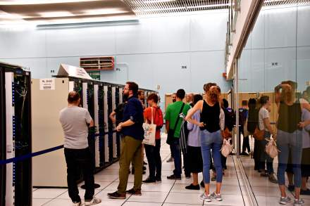 Visitors in a data center between server racks, illustration of cloud environments for AI agents