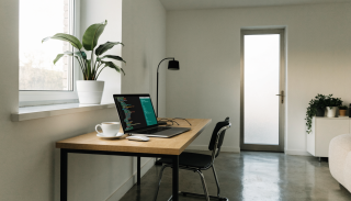 Laptop with a code editor on a desk, symbolizing local PHP development with Flock